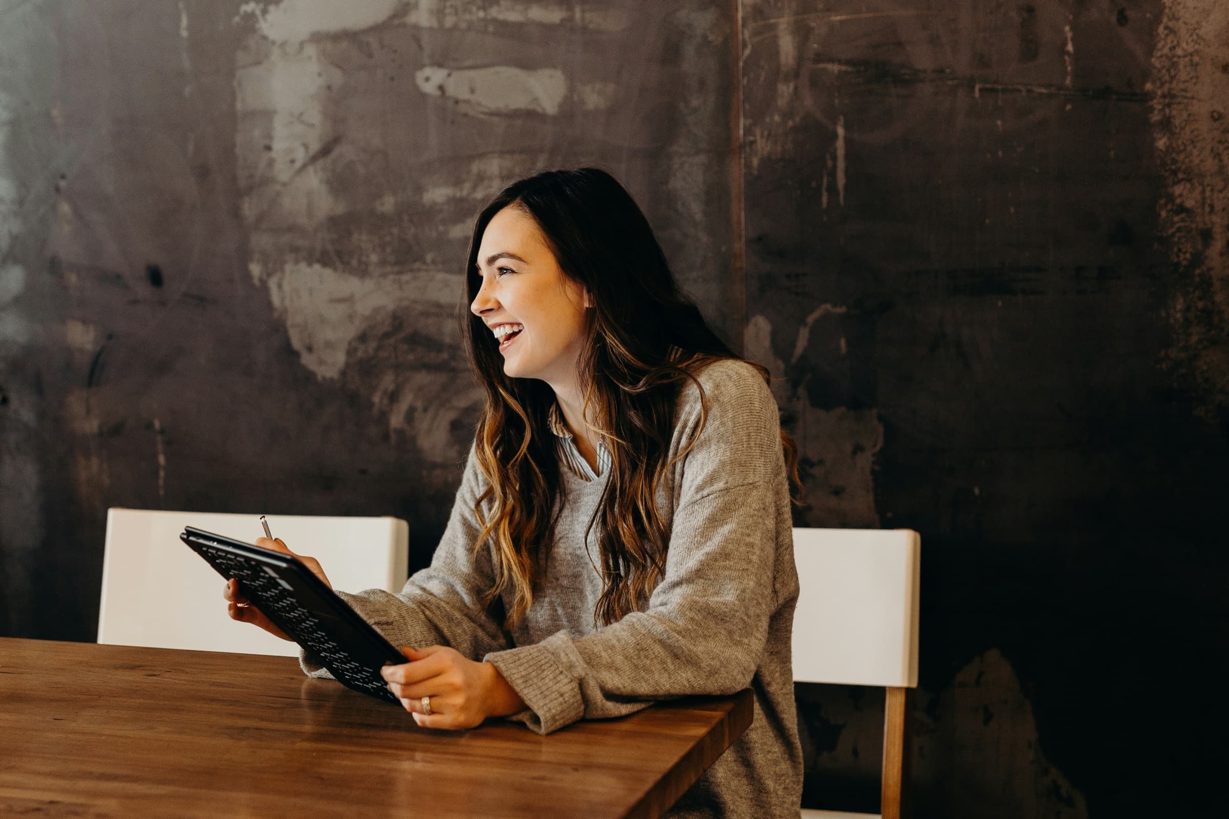 A founder mid-conversation, relaxed and focused, tablet in hand